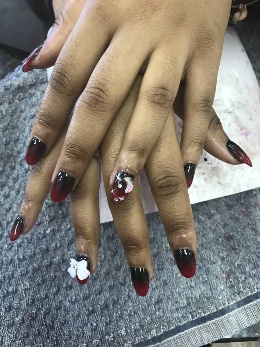 Red-to-black ombré nails with a white floral accent